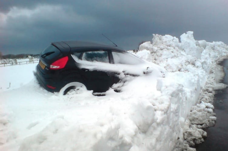 A stricken car falls victim to the 2013 snowstorm