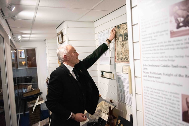 Museum curator Derek Peters makes an adjustment to the displays before the guests arrive