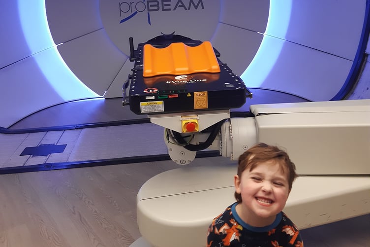 Hector with the multi-million pound proton beam therapy machine that delivered his treatment at the Christie
