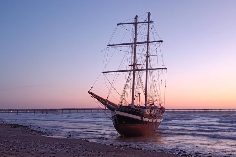 The tall ship La Malouine stranded on Ramsey beach with Queen's pier in the background