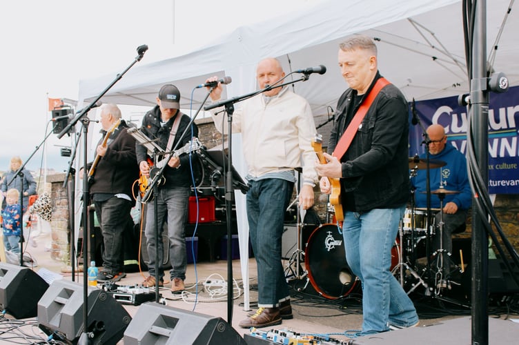 A band was playing for people to enjoy some music as well as the weather
