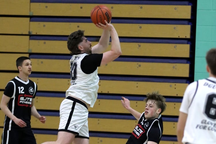 Jack Wilkinson (right) takes the charge for Cannons Elite as DGU Jets' Tom Crosbie goes for the lay-up during their match-up at the NSC last week (Photo: Ben Campbell)