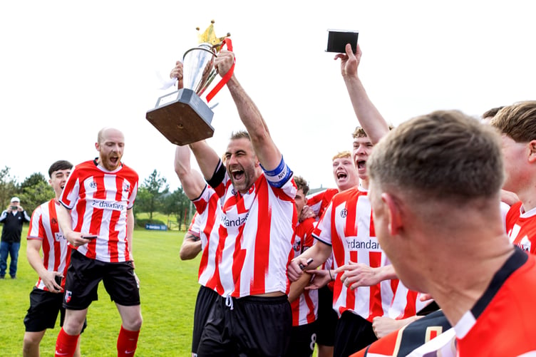 Peel captain Matthew Woods hoists aloft the Premier League trophy as the celebrations get underway at Douglas Road on Saturday (Photo: Gary Weightman)