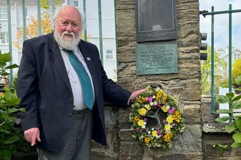 Longstanding World Manx Association member Peter Kelly places the garland at the memorial