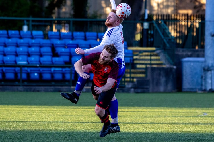 Ramsey's Dominic Parish gets above Onchan's George Reff to win a header during Friday's Junior Cup final at the Bowl (Photo: Gary Weightman)