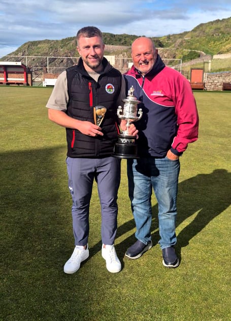 Association Cup winner Stevie Kelly (left) being presented with the trophy by competition committee rep Brian Kelly