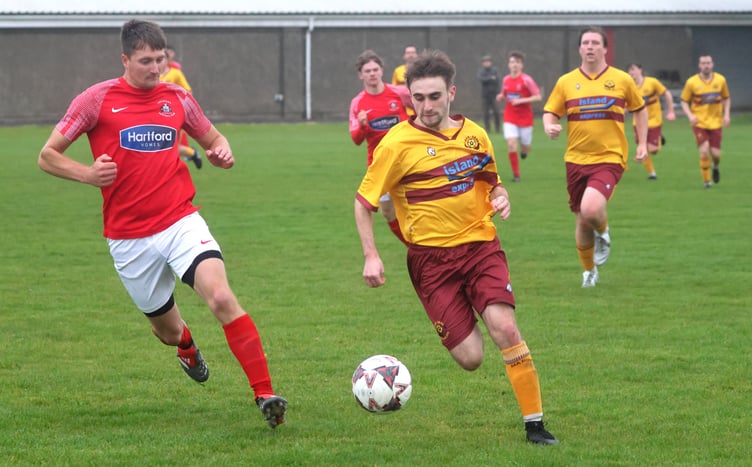 Castletown's Jacob Glover (left) closes down Marown's Tom Redmond during Tuesday evening's second division clash at the Stadium (Photo: Paul Hatton)