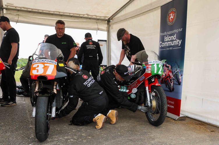 Technical officials inspecting machines in their new overalls at the Pre-TT Classic in May