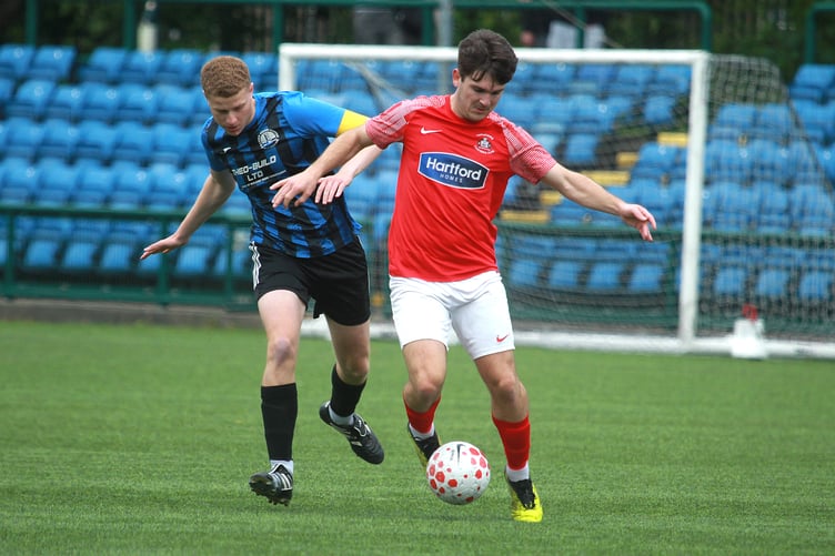 Castletown striker Ross Crawford attempts to escape the attentions of RYCOB captain Will Smith (Photo: Dave Norton)