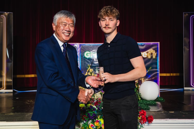 Brandon Callin picking up the Motor Vehicle award – award being presented by UCM Chair of Governors Leslie Wong