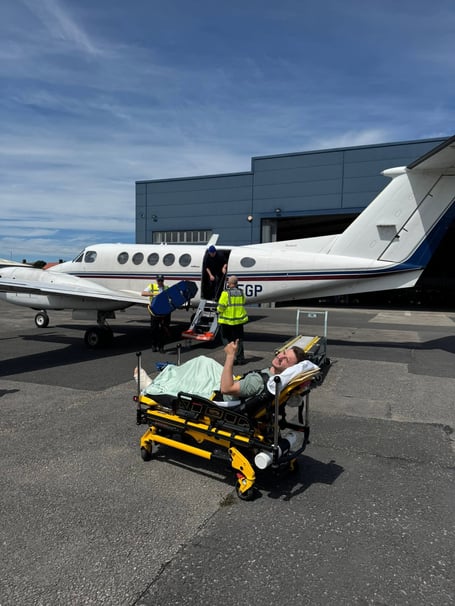 Injured TT competitor Jamie Cringle has been brought back to the island by air ambulance