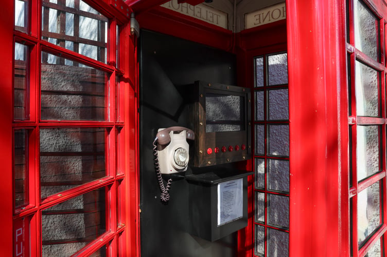 Inside the telephone box, which includes a list of contents for visitors to dial for different information