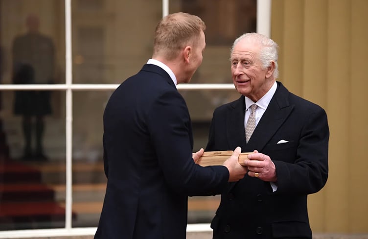 King Charles III hands over the King's Baton to cycling legend Sir Chris Hoy - the first baton bearer - at Buckingham Palace in March last year (Photo: www.glasgow2026.com)