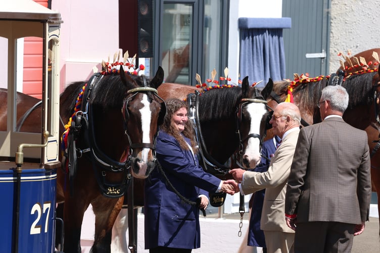 King Charles shaking the hand of one of the Horse Tram workers who care for the Trammers throughout the year