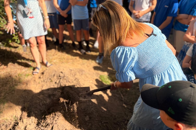 Onchan School head teacher Jo Richardson helps bury the time capsule to mark the school's 150th anniversary