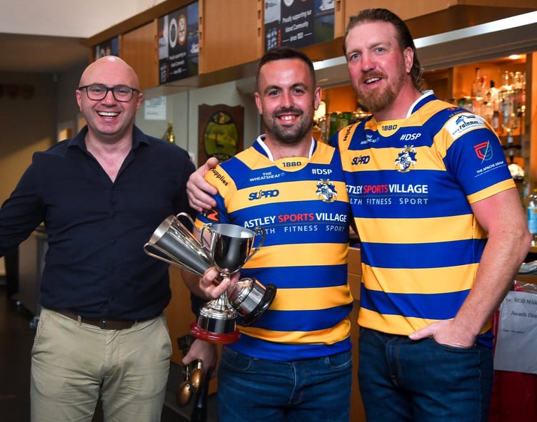 Dan Bonwick (centre) receives the Men’s Captain’s Cup and Player of the Year trophies from former Wales and British Lions international Andy Powell (right) while Vagas chairman John Cannan watches on (Photo: Gemma Lloyd-Jones)