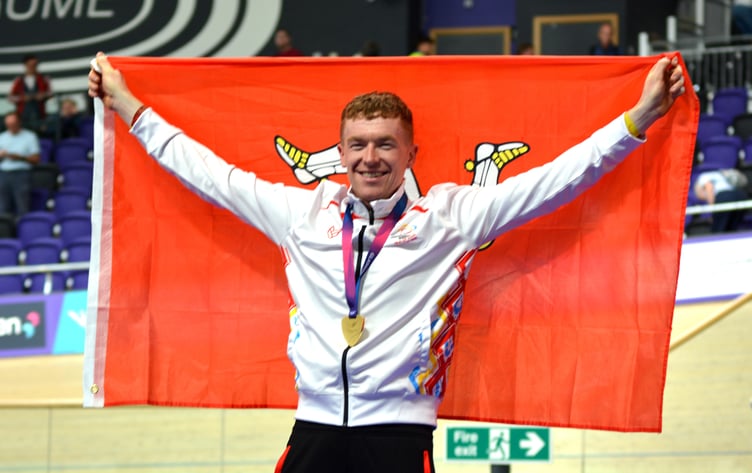Isle of Man cyclist Matthew Bostock celebrates his gold medal with the Manx flag after clinching a superb victory in the men's points race at the Commonwealth Games on Sunday, the very last medal of this year's event in Glasgow (Photo: Andy Dalrymple)