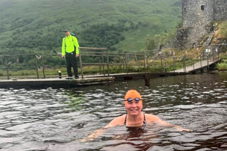 Carole Laporte finishes at Kilchurn Castle Pier after 24 miles in Loch Awe, watched by Ralph Jackson