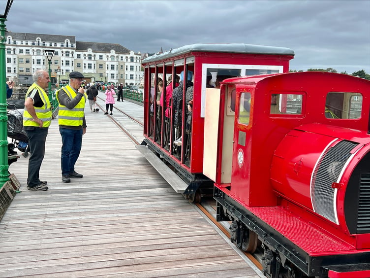 Project manager Dennis Curphey (left) watches as the pier tram arrives at newly restored bay 10, end of the line for now