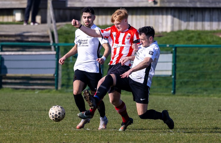 Peel striker Tomas Brown in challenged by Corinthians defender Darren Cain during the two sides' ECAP FA Cup semi-final meeting last season (Photo: Gary Weightman)