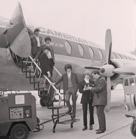 Rolling Stones guitarist Brian Jones being handed a Manx Cat as the band arrived at Ronaldsway in August 1964 (imuseum/Manx National Heritage)