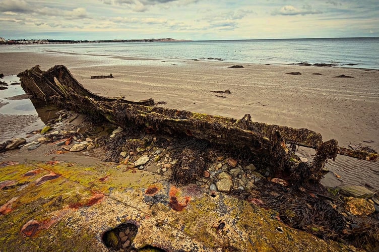 The wreck of the St Cevic on Ballure beach in Ramsey with Queen's Pier in the distance