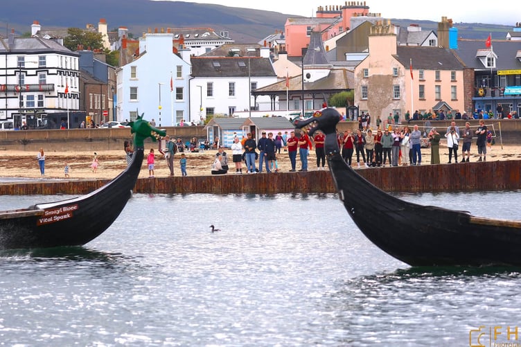 Spectators watch on as two Longboats pass in Peel (Photo: Photo: Frazer Hemming-Allen of FHA Photography)