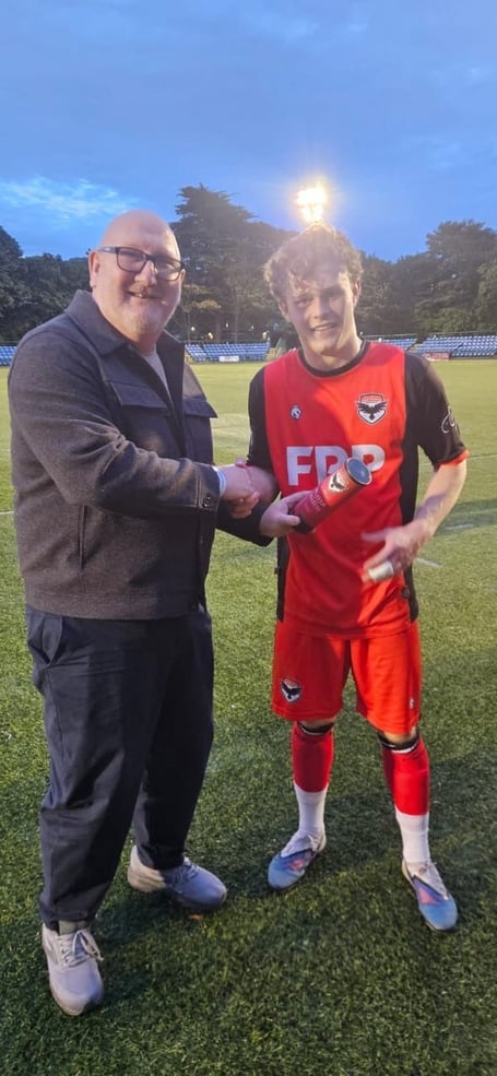 Brian Thomson of match sponsor the Steam Packet giving midfielder Freddie O'Donoghue his Man of the Match award