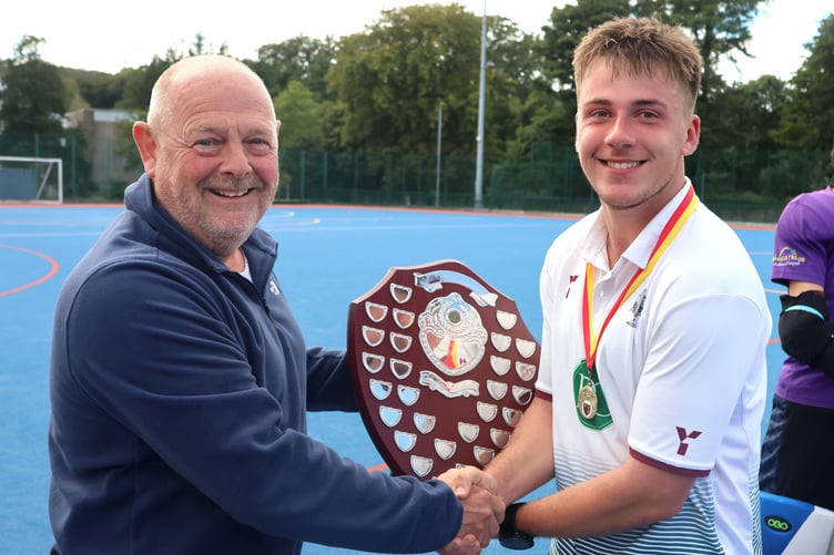 Bacchas A captain Elliot Reid receives the Charity Shield from Manx Hockey Association's Tim Leeming (Photo: Paul Hatton)