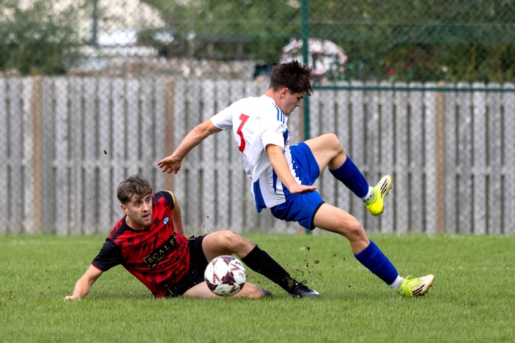 Ramsey's Eliot Cowan is sent hurtling through the air following a challenge from RYCOB's Lewis Moran during Saturday's northern derby at Scoill ree Gorree which the visitors won 3-2 (Photo: Gary Weightman)