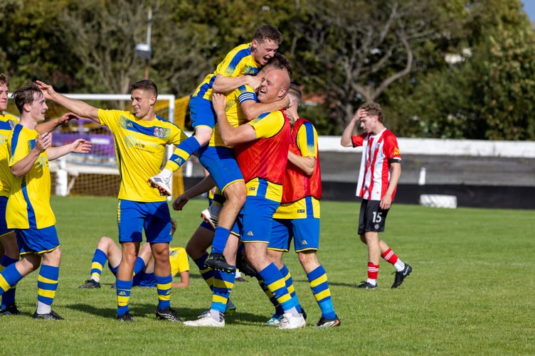 Onchan's Andy Asbridge is mobbed by his team-mates after scoring the winning goal for the Os against Peel on Saturday afternoon, their first win over the westerners for more than six decades (Photo: Gary Weightman)