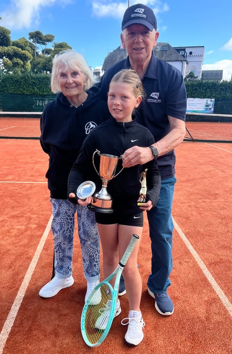 Nine-year-old Zara Stefanovic pictured alongside tournament referee Paul Jarvis and his wife Jaye who presented her with the trophies, including the prestigious Junior Performance Award