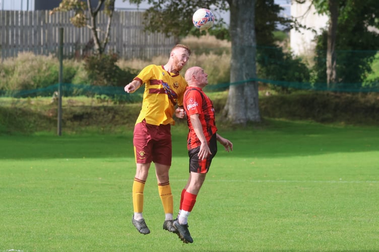 Marown's Harry Barton and Malew's Paul Whitley rise high to challenge for a header at the Memorial Playing Fields (Photo: Paul Hatton)