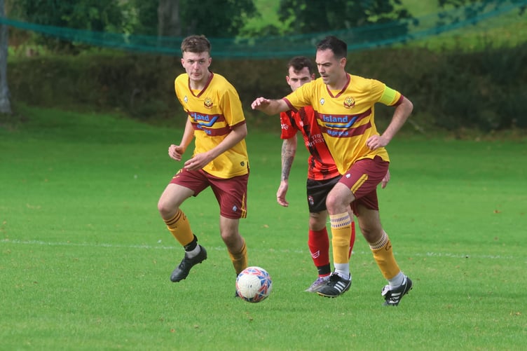 Marown captain Dave Reynolds neutralises a Malew attack and brings the ball forward for the home side (Photo: Paul Hatton)