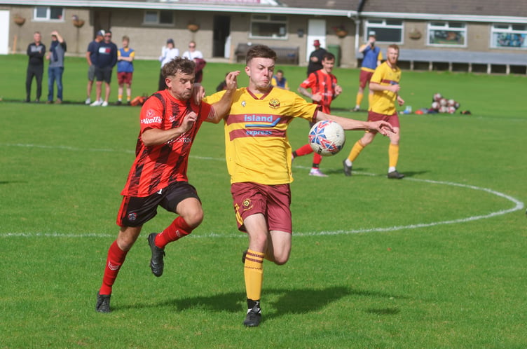 Malew's Paddy Cooper (left) and Marown's Jake Crowe compete for possession during Saturday's match in Crosby (Photo: Paul Hatton)