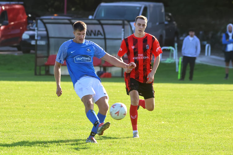 Castletown's Jacob Glover launches the ball forward under pressure from a Malew opponent during the weekend's match (Photo: Paul Hatton)