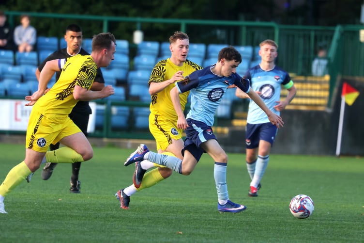 FC Isle of Man's Jimmy Lowther goes on the attack as he looks to escape the attentions of two Widnes Town opponents (Photo: Paul Hatton)