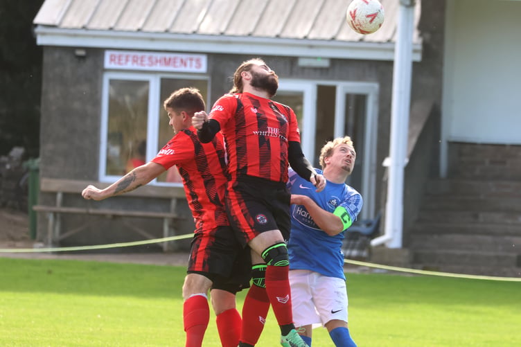 Malew's Craig Cowin rises highest above team-mate Dan Bailey and Castletown's Alex Crawley to win a header during Saturday's derby clash (Photo: Paul Hatton)