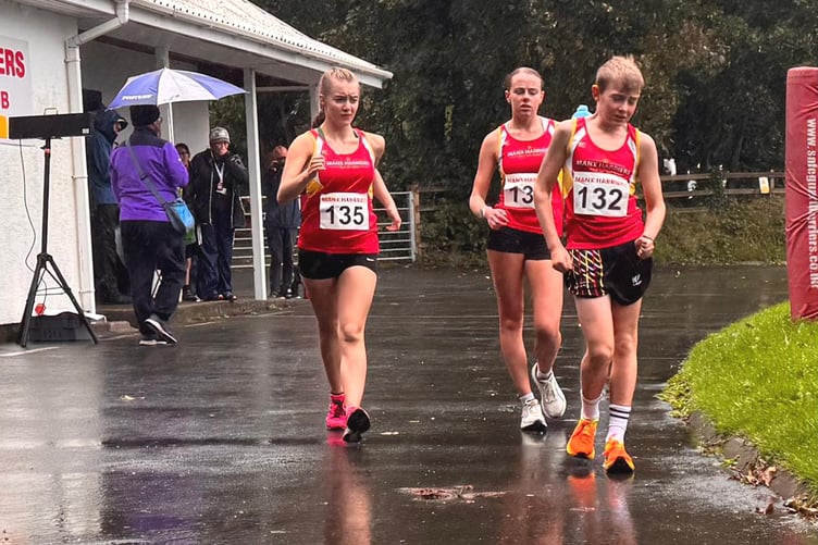 The top three in the half-hour walk, winner Jack Davies leading runner-up Amy Surgeon (left) and third-placed Polly Davies in the wet conditions at the NSC (Photo: Steve Partington)