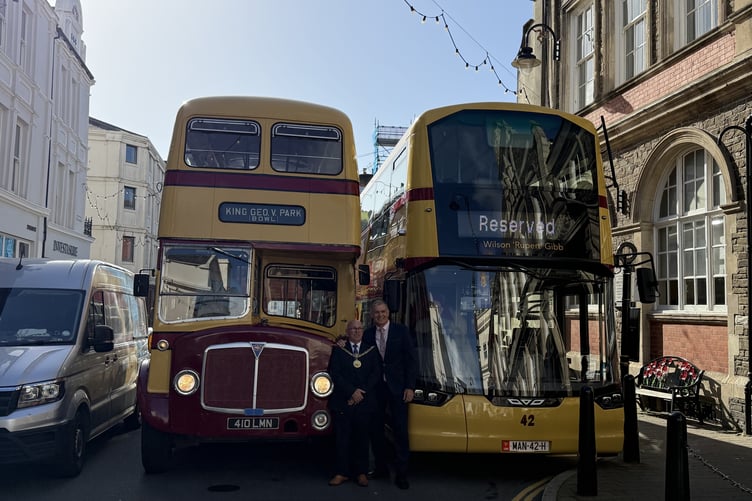 Mayor Steve Crellin alongside Ian Bates in front of two buses steeped in Manx history