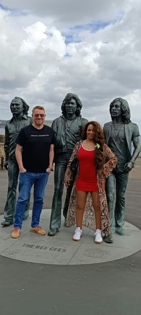 Neal Clague and Rowetta pictured alongside the Bee Gee's statue